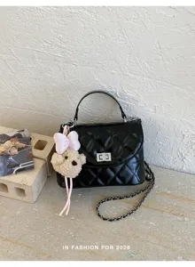 Black quilted chain shoulder bag detail featuring a cute plush bear pendant and chic lock.