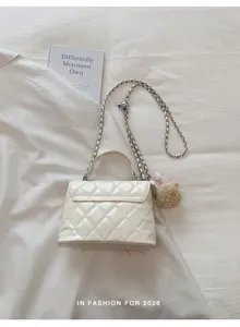 Chic white quilted shoulder crossbody bag with chain strap and cute plush bear pendant accessory.