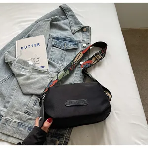 Zwarte nylon crossbody tas met kleurrijke geweven band, casual schoudertas voor dagelijks gebruik.
