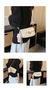 Bolso de hombro acolchado blanco bajo el brazo con cadena y bonito colgante de oso de peluche.