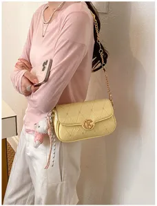 Bolsa de hombro acolchada amarilla elegante con cadena dorada y osito lindo para mujer.