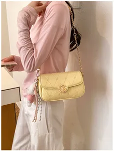 Vista detallada del elegante bolso de hombro acolchado con correa de cadena dorada.