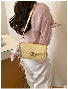 Bolso de hombro de cuero acolchado amarillo con cadena y colgante. Vista detallada.