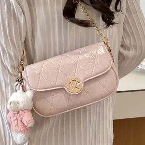 Bolso de hombro rosa de charol acolchado llevado con cadena dorada y lindo colgante de oso.