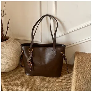 Dark brown leather tote bag detail showing large capacity, chic design and texture.