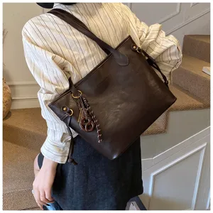Minimalist large capacity commuter tote bag for women, stylish brown shoulder bag with cute charm.