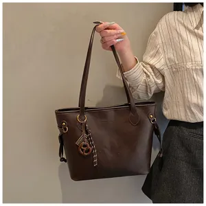 Detail view of the brown leather tote bag showcasing premium texture, exquisite hardware, and unique charm.