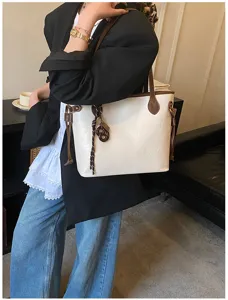 Minimalist large-capacity commuting tote bag for women with stylish strap and contrast details.