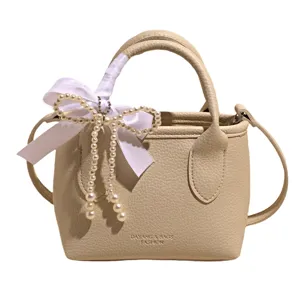 Borsa a mano beige chic in pelle sintetica con elegante fiocco di perle per le donne.