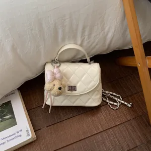 Trendy quilted women's shoulder bag featuring chic chain strap and cute plush bear pendant.