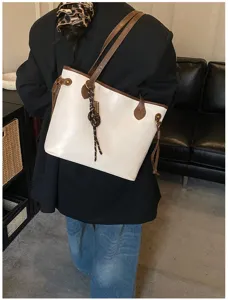 Minimalist large capacity commuting tote bag for women with contrast design and braided charm.