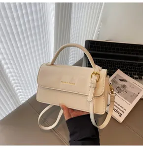 White fashion shoulder bag for women, elegant crossbody handbag with top handle and metal buckle.