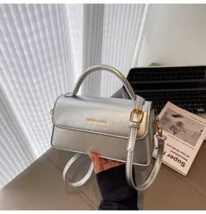 Stylish silver shoulder bag for women, trendy crossbody handbag with top handle and strap.