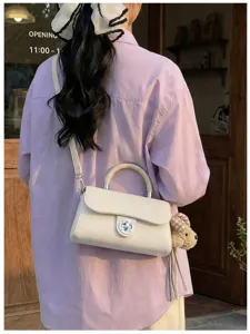 Chic borsa a tracolla bianco avorio con chiusura a girello e ciondolo peluche cane.