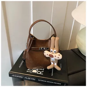 Borsa secchiello in pelle PU marrone con manico e simpatico ciondolo di cartone per donna elegante