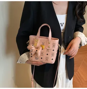 Pink retro bucket bag with cute dog pendant, stylish PU leather crossbody bag for women.