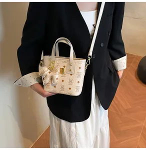 Detailed view of the vintage beige bucket crossbody bag with cute bear pattern and chic handle.