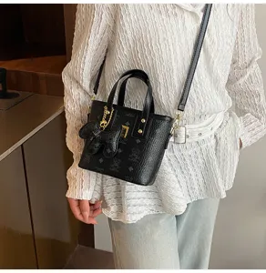 Detailed view of black retro bucket bag with cute bear pendant and stylish crossbody strap.