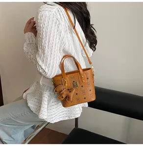 Detailed view of brown vintage monogram bucket bag with cute dog pendant and chic top handle.