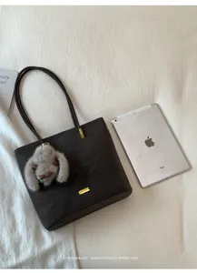 Detailansicht der minimalistischen einfarbigen Schulter-Totetasche mit Plüsch-Häschen-Anhänger.