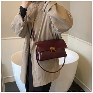 Borsa a spalla bordeaux in pelle verniciata con dettaglio di chiusura metallica quadrata.