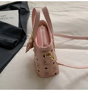 Pink PU leather bucket bag with cute bear monogram pattern, top handle and crossbody strap.
