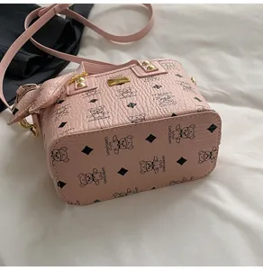 Pink bucket handbag with cute bear print pattern, leather tote and crossbody strap for women.