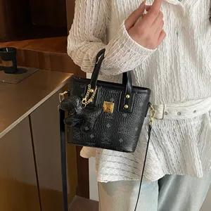 Black vintage bucket bag with top handle and chic bow charm for women daily commute style.