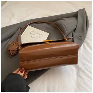 Dettaglio borsa a tracolla in pelle cerata marrone, elegante borsa ascellare quadrata da donna.