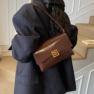 Borsa a spalla da donna in pelle morbida marrone scuro con chiusura dorata elegante