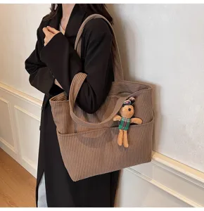 Detail shot of brown corduroy tote bag, large capacity casual handbag with cute plush doll.