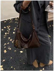 Brown vintage leather shoulder bag for women, minimalist hobo design with chic metal.
