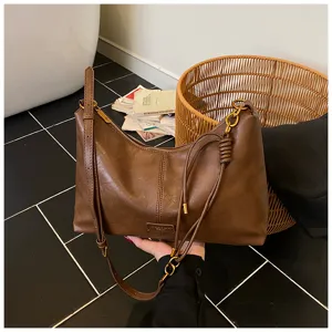 Retro brown hobo shoulder bag with knot strap detail and metallic hardware for women.