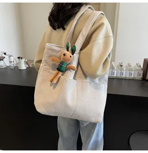 Beige corduroy tote bag for women, large capacity shoulder handbag with cute bunny plush decor.