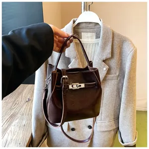 Borsa a secchiello in pelle marrone da donna, elegante tracolla con serratura in metallo.