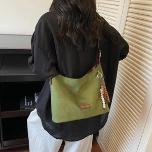 Retro green suede shoulder bag for women, casual hobo tote with beaded charm and comfy strap.