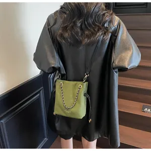 Women vintage suede chain drawstring tote bag detail, retro green crossbody commuting bag.