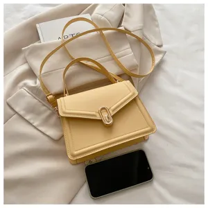 Détail de sac à bandoulière jaune montrant une texture cuir élégante, un fermoir métallique chic.