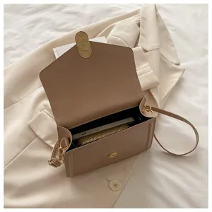 Vue détaillée de l'intérieur du sac à bandoulière en cuir beige minimaliste avec poche.