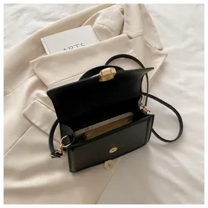 Vue détaillée montrant l'intérieur spacieux et les compartiments du sac à bandoulière noir minimaliste.