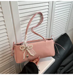 Pink shoulder bag detail, elegant pearl lace bow accessory, stylish underarm bag design.