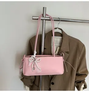 Detailed view of pink shoulder bag with pearl lace bow, stylish commuter underarm bag display.