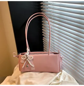 Chic pink shoulder bag with pearl bow, elegant women commuter underarm handbag for daily use.