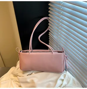 Pink underarm shoulder bag close up, stylish East West baguette bag with thin strap detail.