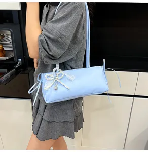 Chic light blue shoulder bag with pearl bow pendant, stylish underarm bag for women daily commute.