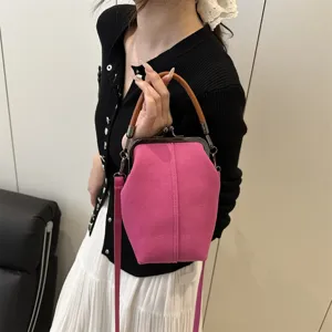 Pink denim crossbody bag with kiss-lock closure, stylish shoulder handbag for women.