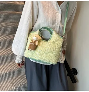 Vue détaillée d'un sac à bandoulière texturé vert minimaliste frais avec pendentif ours.