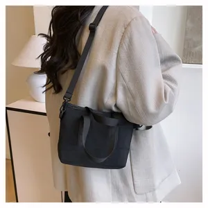 Black canvas crossbody bag for women, casual minimalist small shoulder bag with adjustable strap.