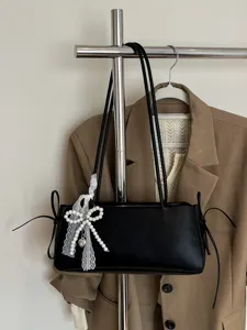 Black minimalist shoulder underarm bag with pearl lace bow charm for women casual commuting.