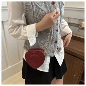 Rode hartvormige mini-schoudertas met gewatteerd patroon en stijlvolle goudkleurige ketting.